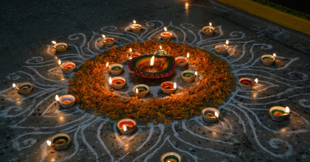 Clay diyas set in a colourful rangoli for Diwali (photo: siddarth varanasi, Wikimedia Commons, CC BY 2.0)